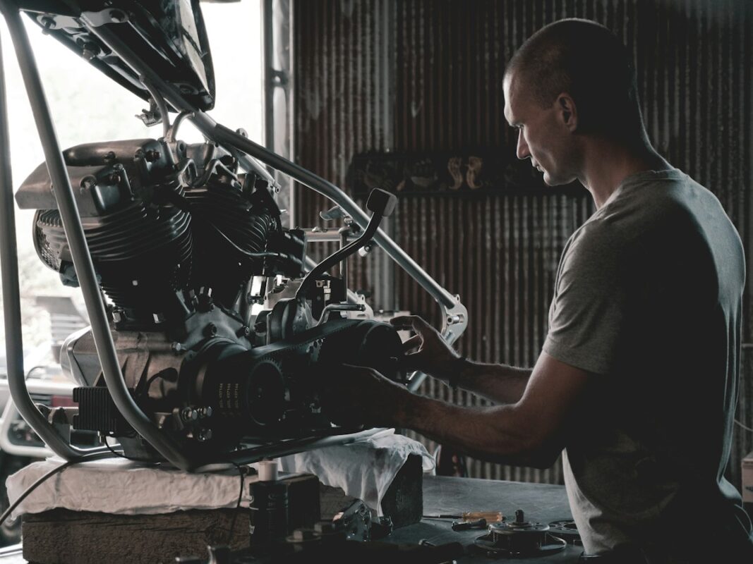 Mecánico trabajando en el motor de una moto en el taller