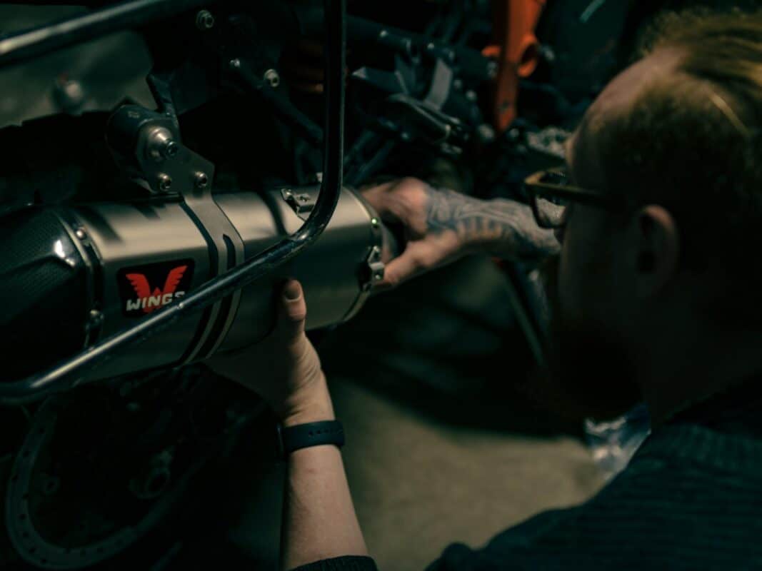 Mecánico trabajando en una moto con llave inglesa