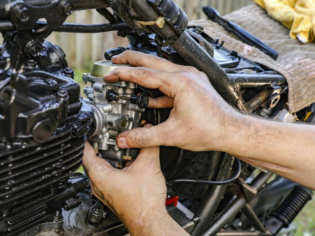Manos de mecánico en el motor de una moto